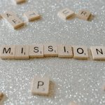 Scrabble tiles spelling 'Mission' on a sparkling surface convey determination and goals.